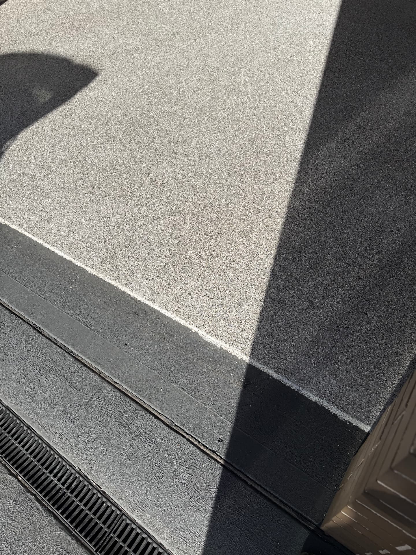Close-up of a flake epoxy edge detail against a dark coated apron